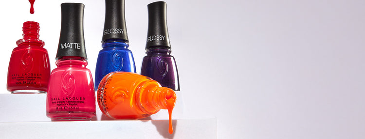 Four bottles of nail lacquers in red, pink, blue, and orange on a white background